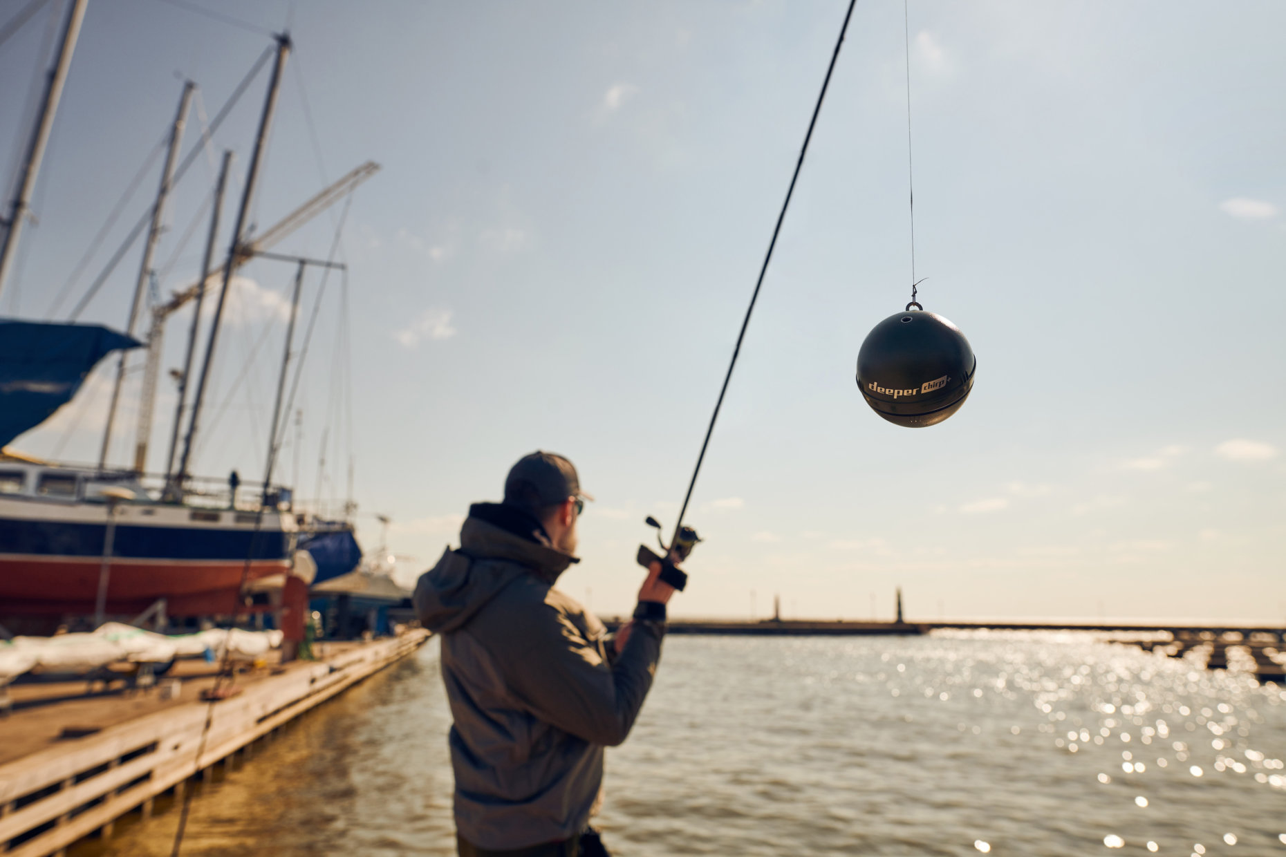 Man with fishing pole in the harbour