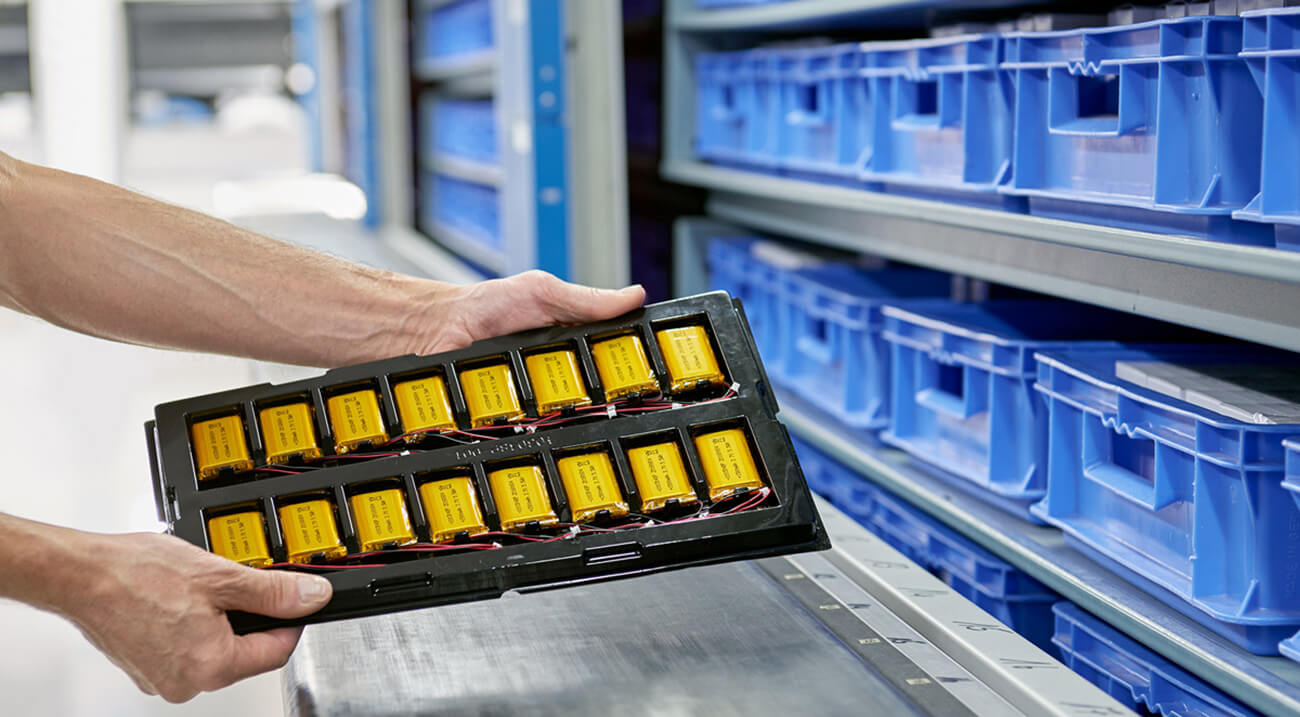 Two hands hlding a tray of lithium polymer batteries