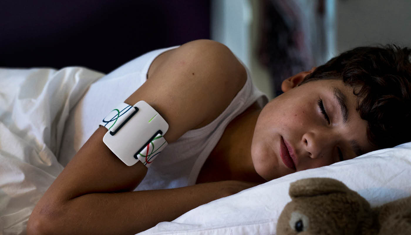 Young child sleeping and wearing the NightWatch armband.